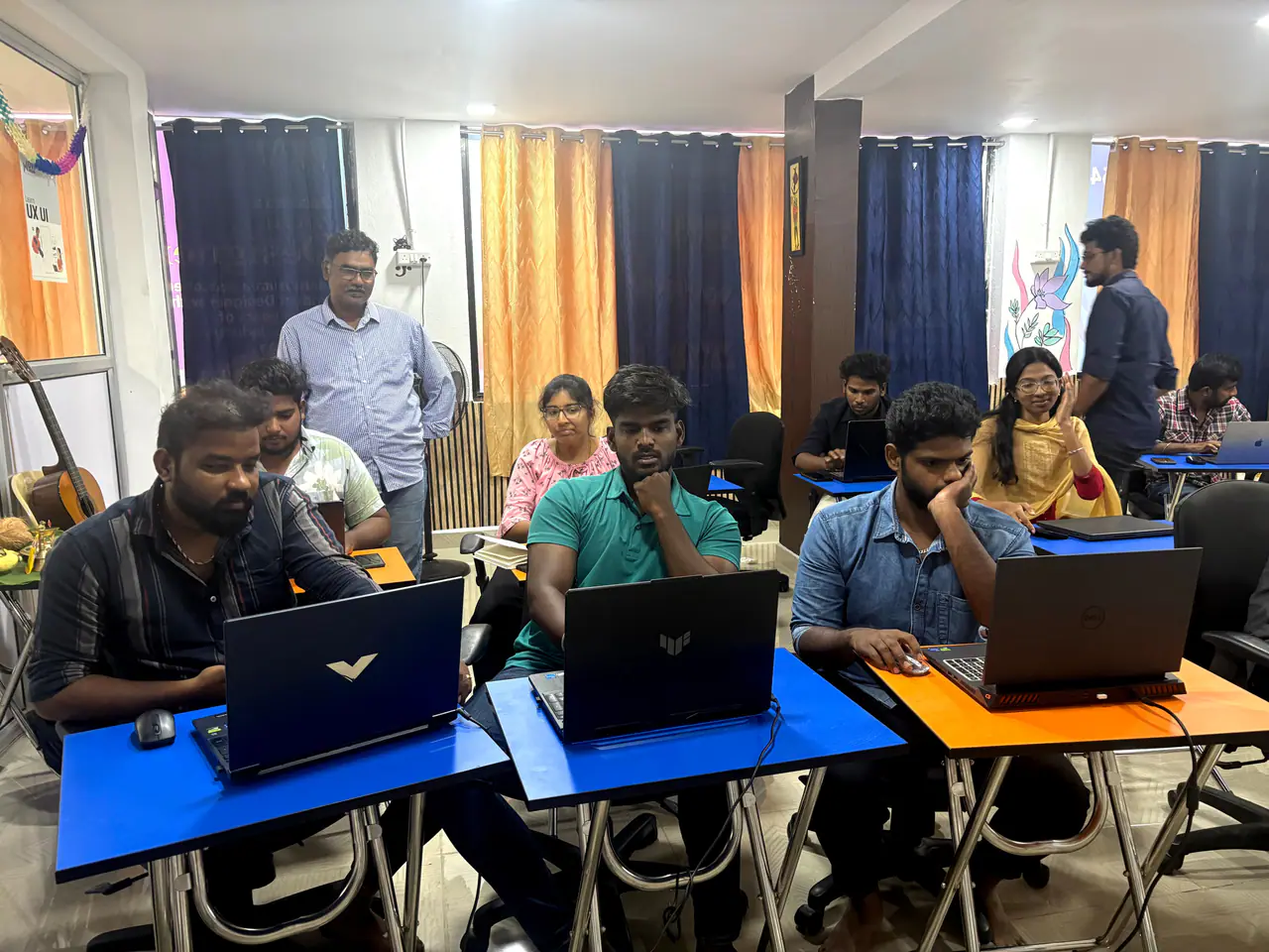 Students working on UX/UI projects on their laptops in class